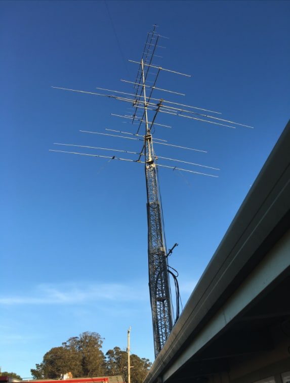 Lattice tower with a multi-element beam antenna against a blue sky